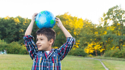 happy boy holds a globe on his head.