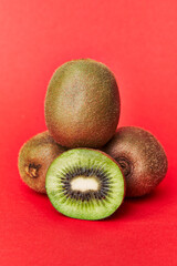  Bunch of kiwis and slice on a red background