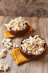  Bowls of salty popcorns on a wooden surface