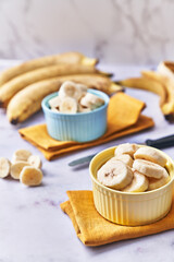  Bowls of slices of banana on a marble table