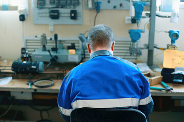 Training in working specialties. Young worker sits at desk with equipment in training center. Advanced training and training of technicians and locksmiths. Instrumentation and automation.