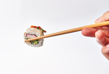 Chopsticks holding single surimi uramaki sushi isolated on white background