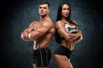 Sporty couple showing muscles. Muscular man and woman - 473122123