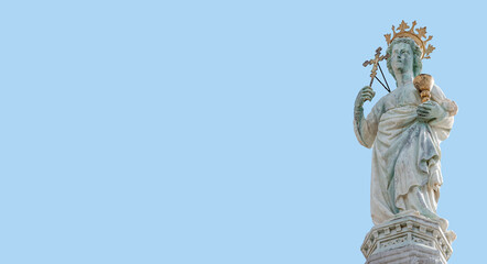 Fototapeta na wymiar Banner with ancient statue of Maria with cross and holy grail at the roof top decoration of Doge Palace in Venice, Italy, at blue sky background with copy space. Concept of architecture heritage sites