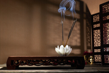 Smoke from burning incense sticks standing on lotus incense holder - obrazy, fototapety, plakaty