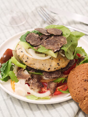 A high protein mince chicken breast  burger with sliced black truffles and assorted of green fresh...