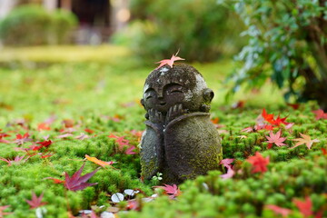 ほのぼの石像、苔と紅葉に囲まれて幸せに