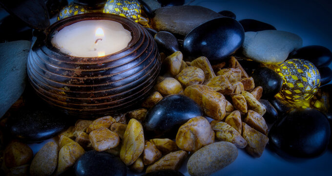 Zen balancing stones and a lighted candle in a relaxed atmosphere
