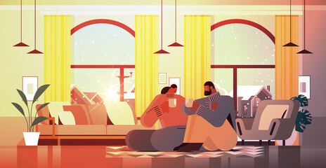 african american couple drinking coffee and talking together at home living room interior horizontal