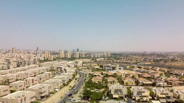 Flight backward with panoramic over expensive districts in Beer-Sheba city with private buildings and towers