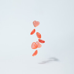 Soft heart candy dropping on the pastel blue background. Romantic gift minimal concept