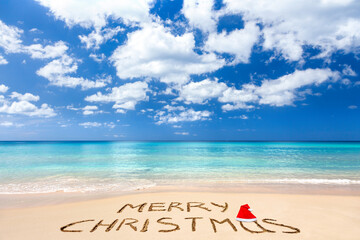 Fototapeta na wymiar Merry Christmas written on a sandy beach