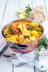 Traditional French fish bouillabaisse with seafood and fish fillet served as close-up in a rustic casserolle