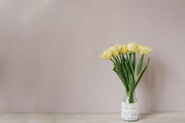 Bouquet of yellow tulips in a vase. Spring flowers. Bouquet in a vase. Cozy still life. Copy space. A festive greeting.