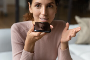 Close up cropped of woman recording audio message on smartphone, positive young female chatting with friends in social networks, making phone call by speakerphone, activate digital voice assistant