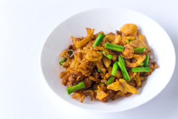 Stir fried crispy pork and yardlong bean with Thai spicy curry paste on white plate in Thai food style.