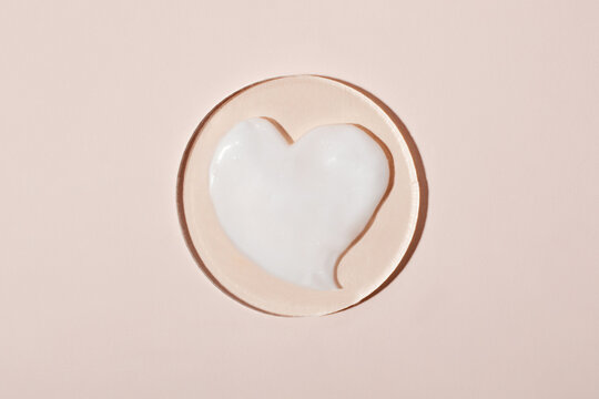 Swatch of cosmetic cream in form of heart.Pastel background,good as mockup.