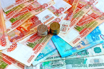 Paper ruble bills with a pile of small metal coins
