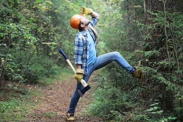 Male lumberjack in the forest. A professional woodcutter inspects trees for felling.