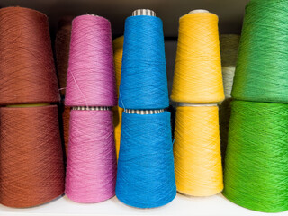 Set of colored wool yarn threads on bobbins.
