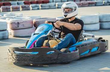 A young man drives a go kart at circuit - obrazy, fototapety, plakaty