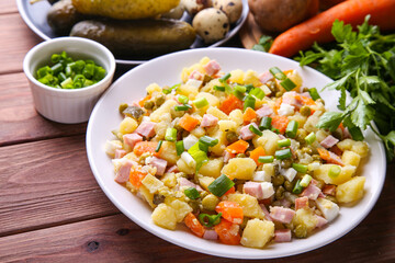 Traditional Russian salad Olivier for Christmas and New Year on a wooden background. Close up view