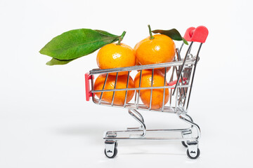 fresh mangerines and a shopping cart on a white background