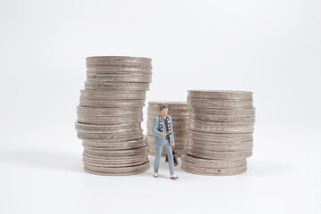 the mini figure stand  before of pile of coins.