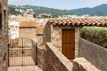 stone house with a wooden door and a metal fence in the town of Tossa de Mar in Spain