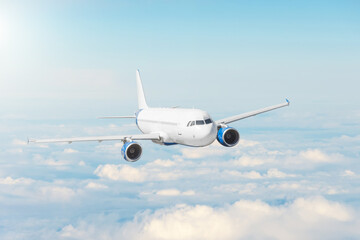 Naklejka na ściany i meble Airplane flying in blue sky above the clouds, travel by plane, international flight.