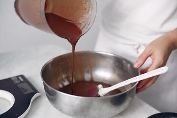 Chef in white clothes prepares a chocolate cake.