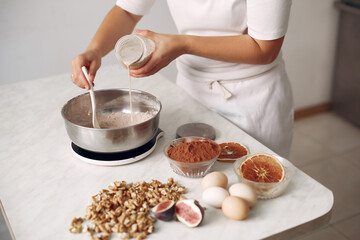 Chef in white clothes prepares a chocolate cake.