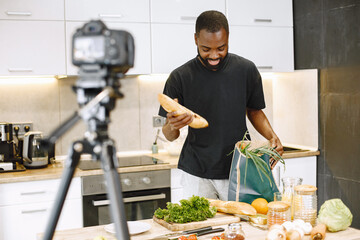 African male blogger recording vlog on digital camera