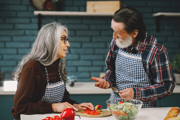 Senior couple cooking healthy food at house kitchen