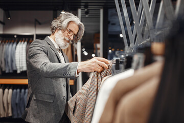 Senior man choosing a new suit in a store
