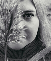 Attractive plus size girl sitting in black lingerie with a branch in her hands