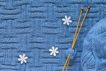 Winter knitting and needlework. Hand knitted  warm blue scarf, woolen yarn, wooden knitting needles...