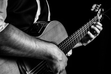 Hombre elegante tocando la guitarra clásica. Fotografía en blanco y negro
