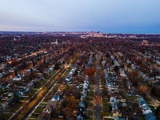 Obraz premium Dawn breaking over suburb in early winter, downtown in the background, lights from houses and streetlights still lit.