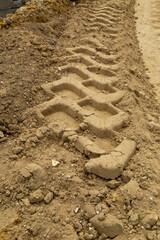 Gros plan sur des traces de pneus d'un engin de chantier travaux publics terrassement