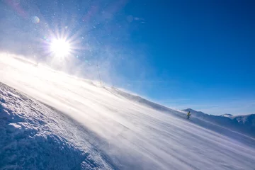 Fotobehang Lone Skier on a Sunny Slope and Blizzard © goodman_ekim
