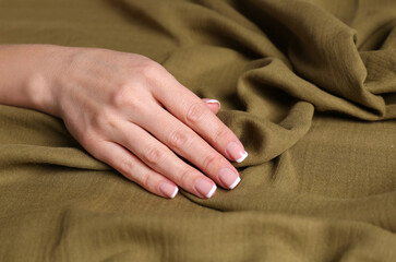 Woman touching soft linen fabric, closeup view