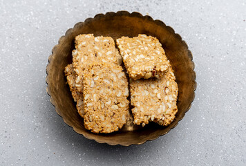 Gajak or til patti is a dry sweet cake - made of sesame seeds, ground nuts and jaggery, consumed in...