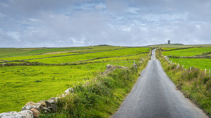 Obraz premium Country road leading to Moher Tower at Hags Head in Cliffs of Moher, popular tourist attraction, Wild Atlantic Way, County Clare, Ireland