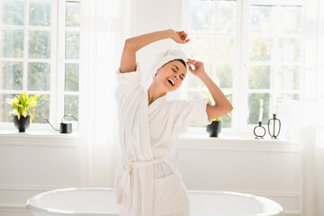 Energetic cheerful caucasian mature middle-aged woman in turban after taking shower bath in spa...