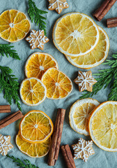Fototapeta na wymiar Arrangement of dry oranges, gingerbread cookies and cinnamon sticks.