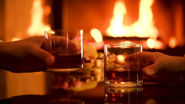 Young couple has romantic dinner with whiskey
 over fireplace background. Romantic concept.