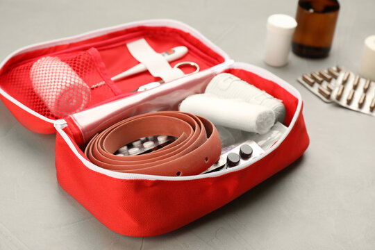 First aid kit on grey table, closeup