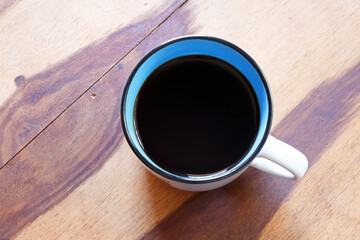 BLACK COFFEE IN A MUG ON A WOODEN TABLE