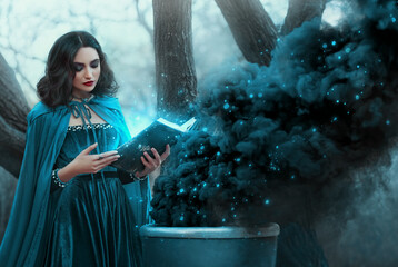 Halloween woman witch conjures, holds book in hands reads spell black magic smoke rises from...